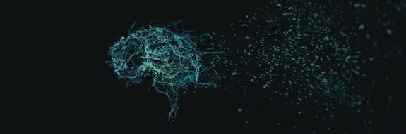 Digital brain visualization with glowing teal particles dispersing against black background. 